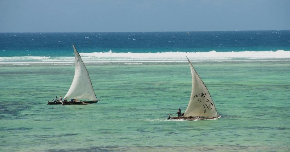 Beach Holidays Review — Portrait of Two Sailboats on the Turquoise Water of the Zanzibar Beach, Tanzania.