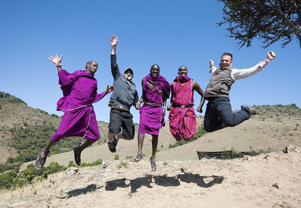 G adventures tour review — maasai men and tourists jumping.