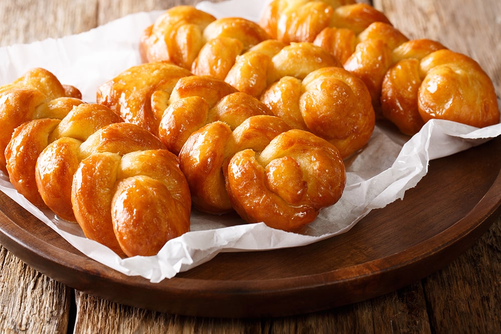 Traditional foods of south africa — close-up of a plate with koeksisters, a south african deep-fried sticky donut.